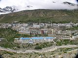 Tibet Kailash 02 Nyalam 04 View of Town I passed the checkpoint at the eastern edge of Nyalam and climbed briefly up the ridge to a small pass festooned with prayer flags. From there, I had a good view of Nyalam with the clouds billowing up from Zhangmu.